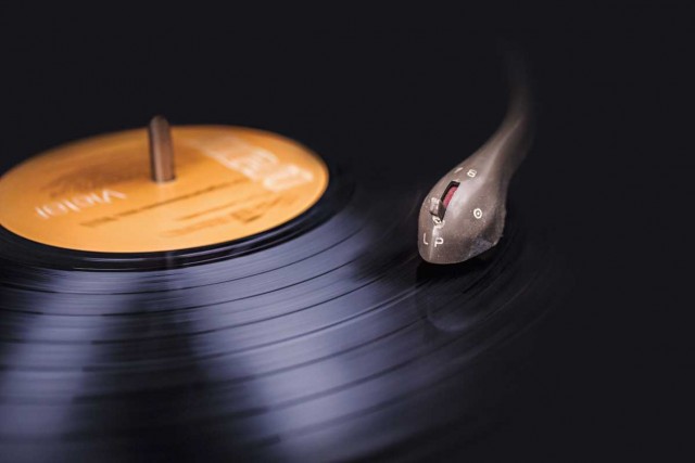 Vinyl record close-up showing the stylus and the rings of the vinyl record shimmering in the light.