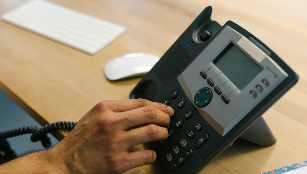 Business Telephone - Person Dialing the Telephone