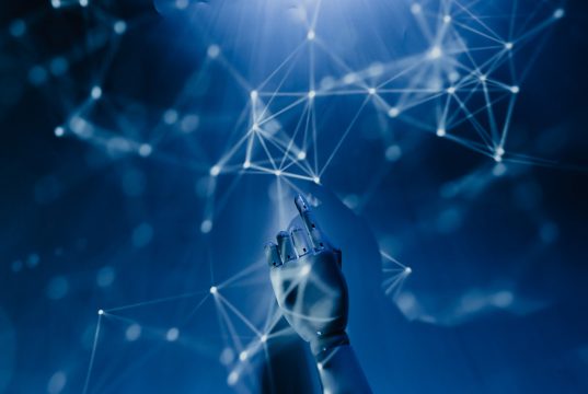How A.I. is changing the Contact Centre Industry An abstract imagerepresenting Artificial Intelligence. A dark blue gradient that seems like it could be underwater with lots of nodes and interconnecting lines along witth a robotic hand reaching up from the bottom and pointing into the nodes.